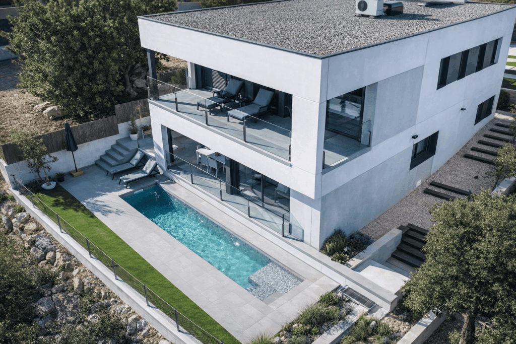 Vista aérea de una casa moderna con piscina y jardines exteriores bien cuidados