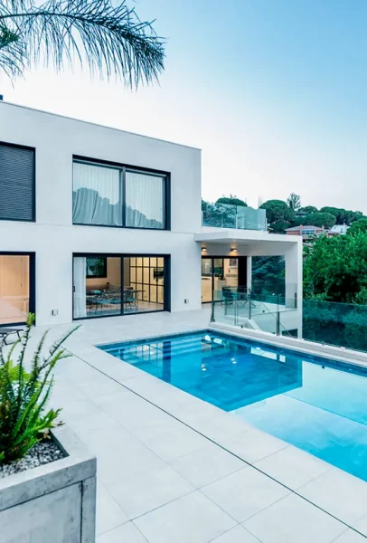 Casa moderna con piscina en Valencia, destacando el diseño minimalista y el ambiente relajado del exterior, rodeado de naturaleza.