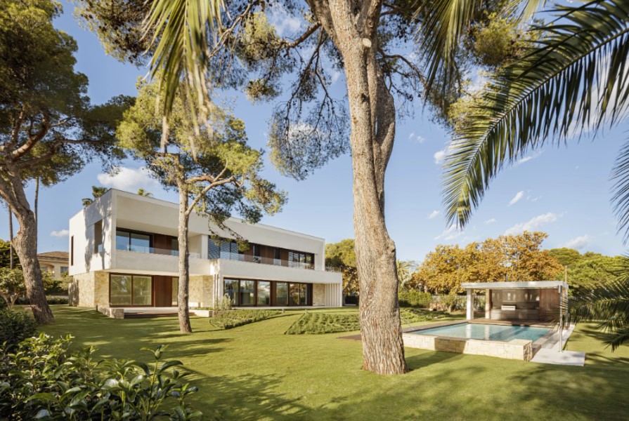 Vivienda prefabricada de hormigón integrada en el paisaje mediterráneo con jardín y piscina