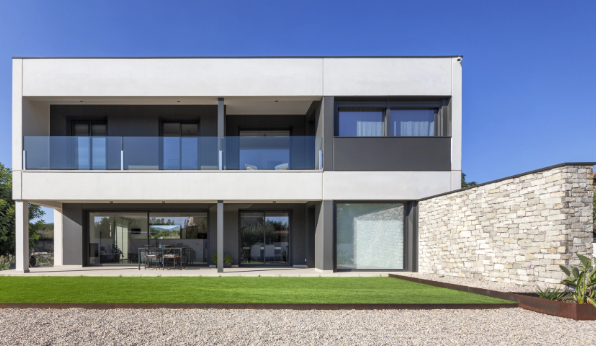 Casa prefabricada premium de hormigón con arquitectura contemporánea, grandes ventanales y fachada de piedra